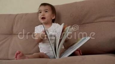 小女孩坐在柔软的沙发上笑着，翻开一本五颜六色的书页
